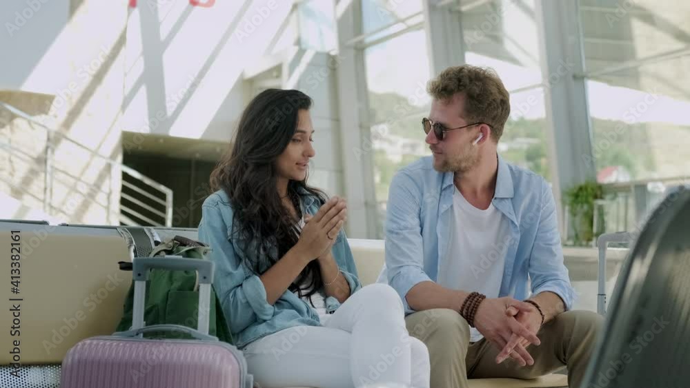 Couple of tourists sitting at the station and talking Couple of tourists sitting at the station and talking