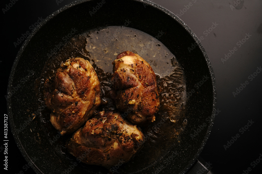 Fototapeta premium Large pieces of chicken fried in a frying pan. Top view.