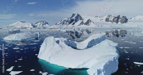 Closeup polar seascape with iceberg at ocean bay aerial. Snow covered mountain at coast. Arctic melting fiord of ice. Global warming environment preservation. Cinematic climate change at Antarctica