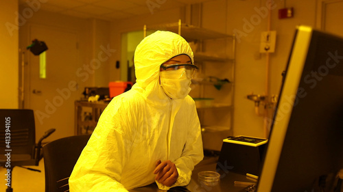 Person analyzing bacterial samples in office with maximum biosecurity
