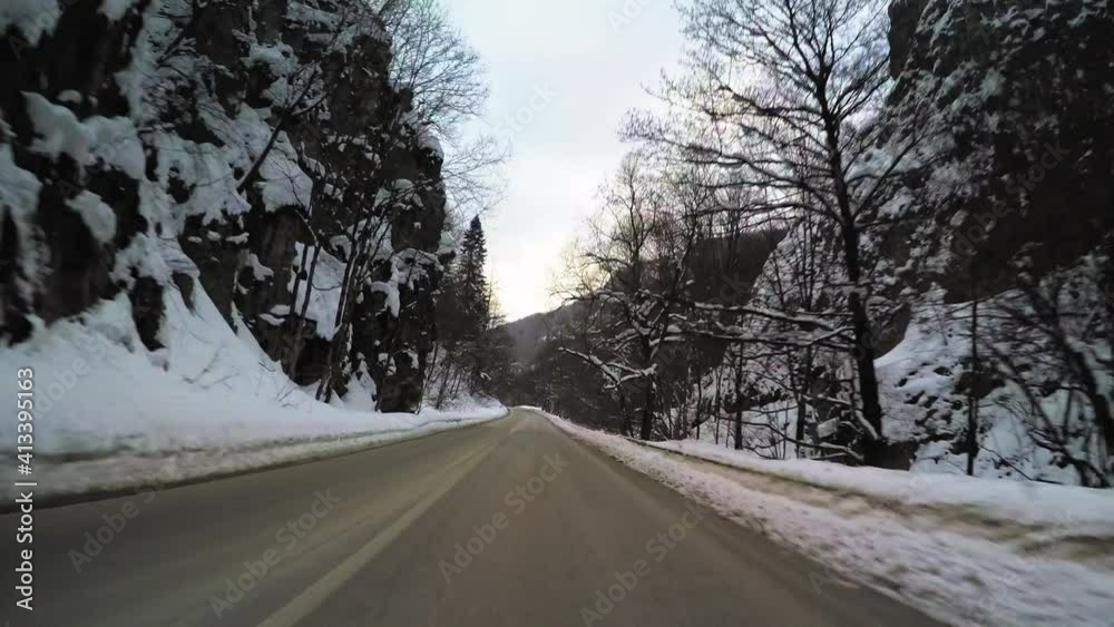 POV vehicle drive across countryside, mountain rocky scenery, winter snow, wet narrow curvy road, forest trees and clouds blue sky, car travel point of view POV vehicle drive across countryside, mountain rocky scenery, winter snow, wet narrow curvy road, forest trees and clouds blue sky, car travel point of view