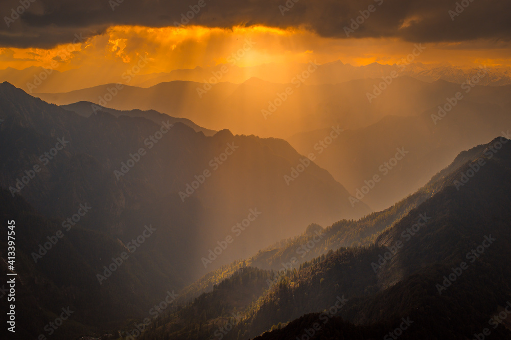 Sunset over the mountains. Serene golden hues of sun rays at Himalayan snowscapes mountains, Parvati valley, Kasol, Himachal Pradesh, northern India.