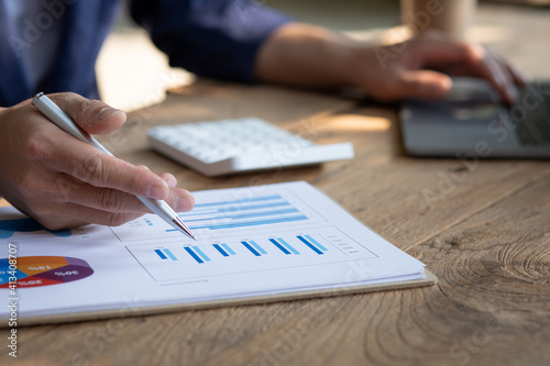 Close up businessman hand using calculator and working with laptop calculate about finance accounting at coffeeshop outdor.finance accounting concept