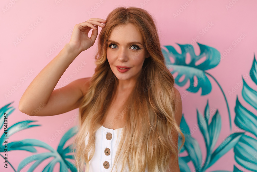 Portrait young smiling blond caucasian woman posing on pink wall background. Summer tropical vacation Portrait young smiling blond caucasian woman posing on pink wall background. Summer tropical vacation