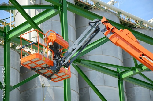 Cuadro en lienzo Worker are driving the Orange articulate boom lift or telescopic boom lifts and bucket crane mounted on truck to safety for working at heights and articulating boom lift reaching high up