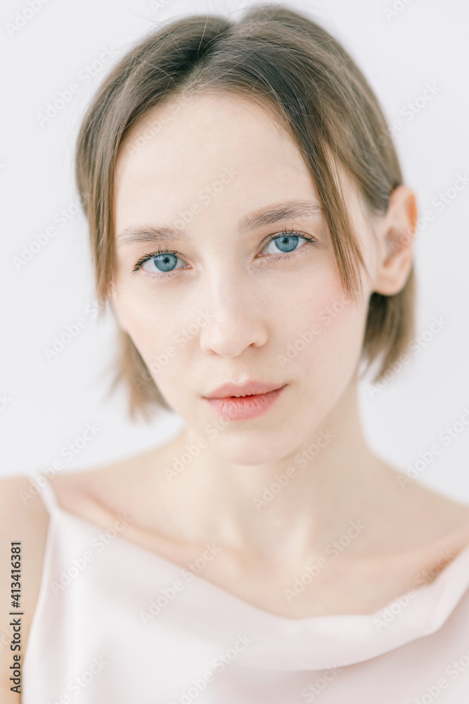 Portrait of a beautiful woman in an evening dress on a light background. Expressive look of the model on a sensual face, neutral makeup. Portrait of a beautiful woman in an evening dress on a light background. Expressive look of the model on a sensual face, neutral makeup.