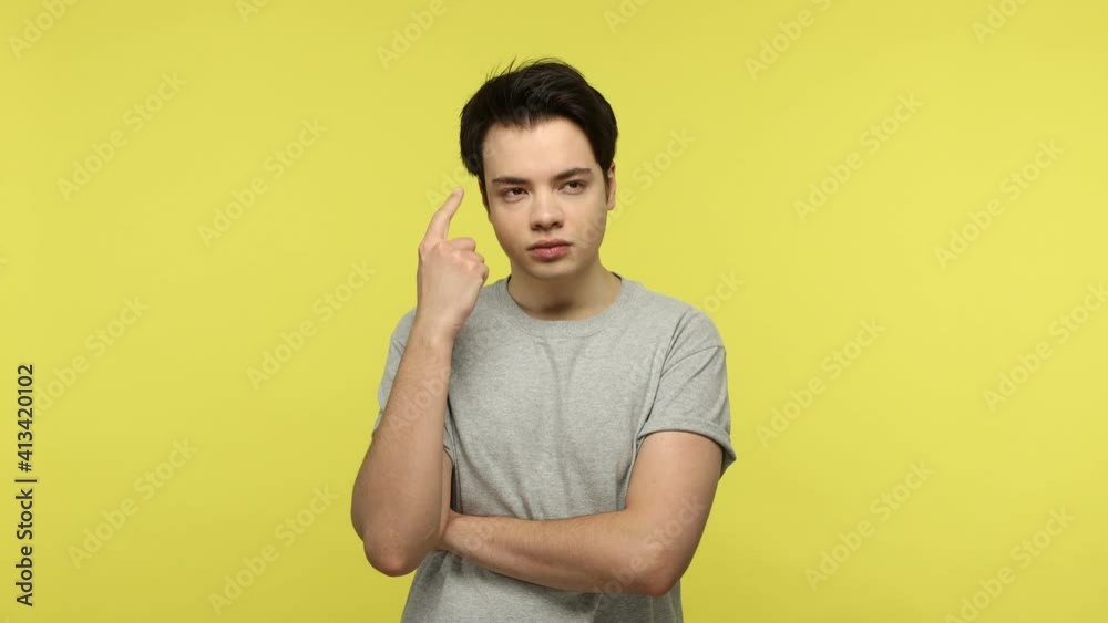 Confused puzzled brunette man in gray t-shirt looking with suspicion and doubt at camera, considering serious choice, making hard decision. Indoor studio shot isolated on yellow background Confused puzzled brunette man in gray t-shirt looking with suspicion and doubt at camera, considering serious choice, making hard decision. Indoor studio shot isolated on yellow background