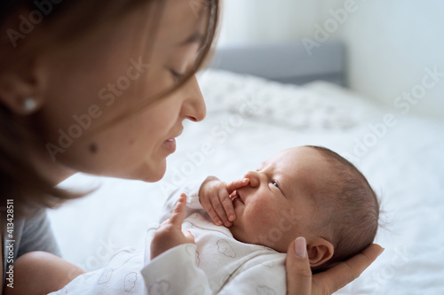 Pretty baby boy on mother hands in room closeup. Motherhood. Childhood. . High quality photo