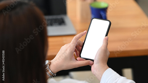 Close up view of businesswoman sitting on chair in office a using mobile phone.