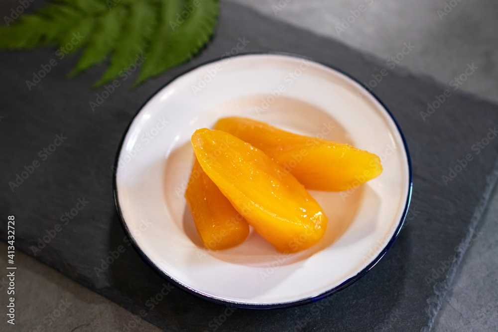 Sweet potato or Yam in syrup usually served coconut milk in vintage zinc coating dish on black stone background. Traditional desserts in Thailand. Sweet potato or Yam in syrup usually served coconut milk in vintage zinc coating dish on black stone background. Traditional desserts in Thailand.
