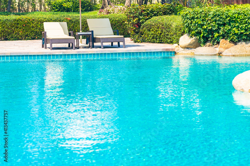 Outdoor swimming pool with sea ocean beach around umbrella and chair