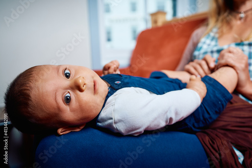 Baby resting in mother's lap at home