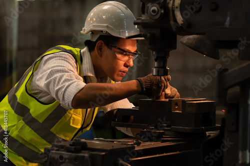 Industry engineer wearing safety uniform measure the object control operating lathe machine working in industry factory.