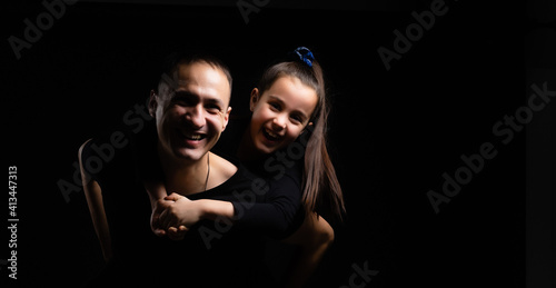 father and daughter on black background