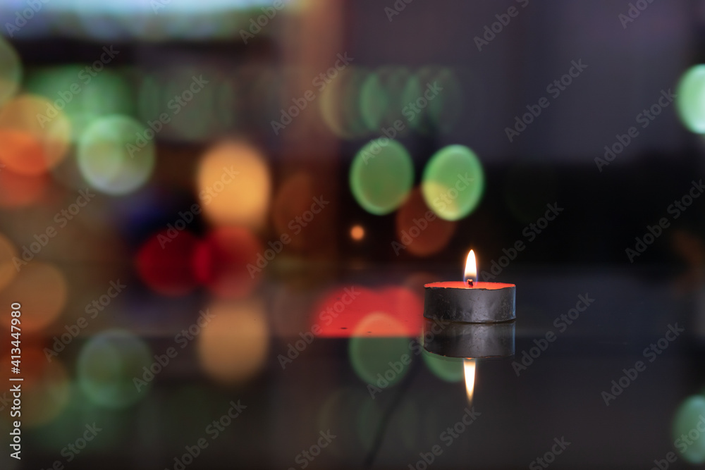 © James Jiao - candles with reflection on glass table setting. moving blurred colorful city night in background