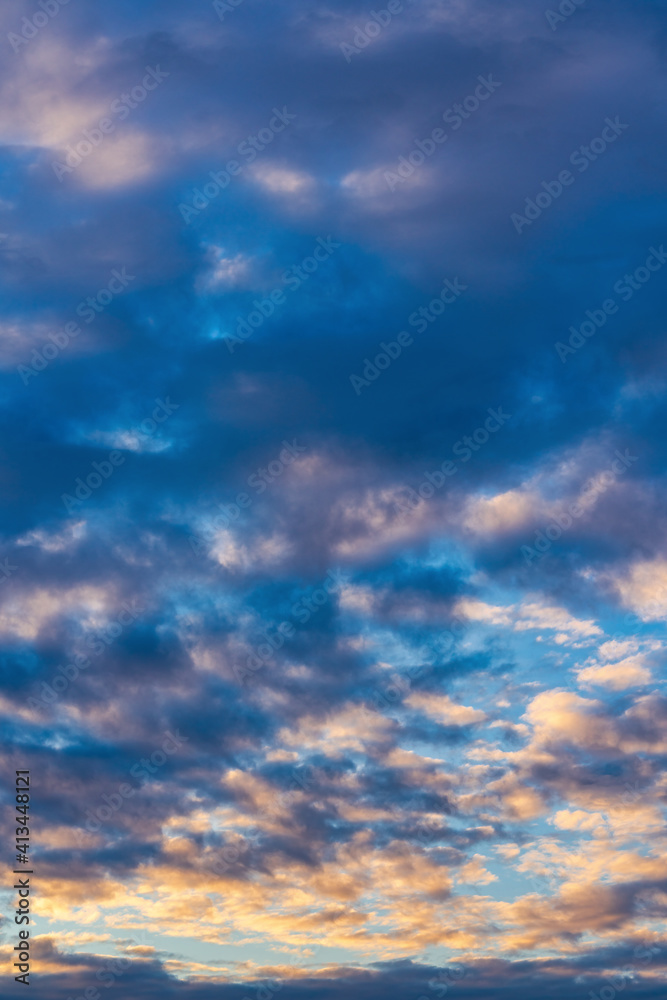 Beautiful clouds in blue sky, illuminated by rays of sun at colorful sunset to change weather. Soft focus, motion blur abstract meteorology background.