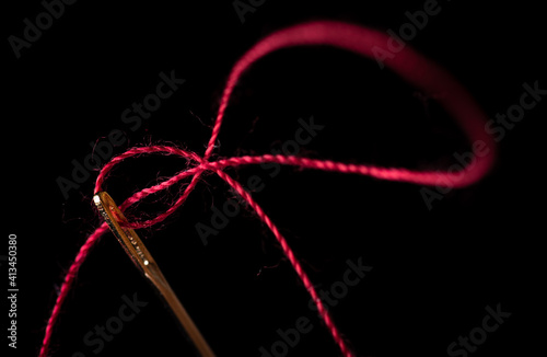 needle and thread on a black background 