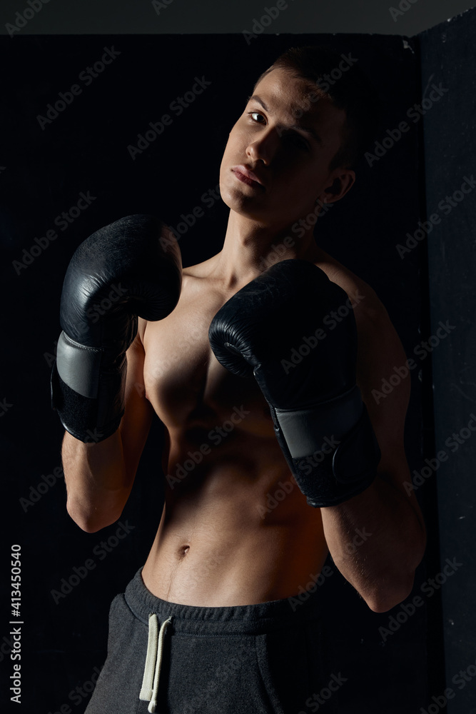 athlete in boxing gloves on black background portrait cropped view 