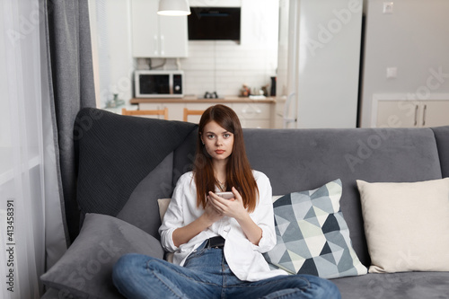 Free Download woman with a phone in her hands sitting on a comfortable sofa leisure weekend technology - GFXLoad