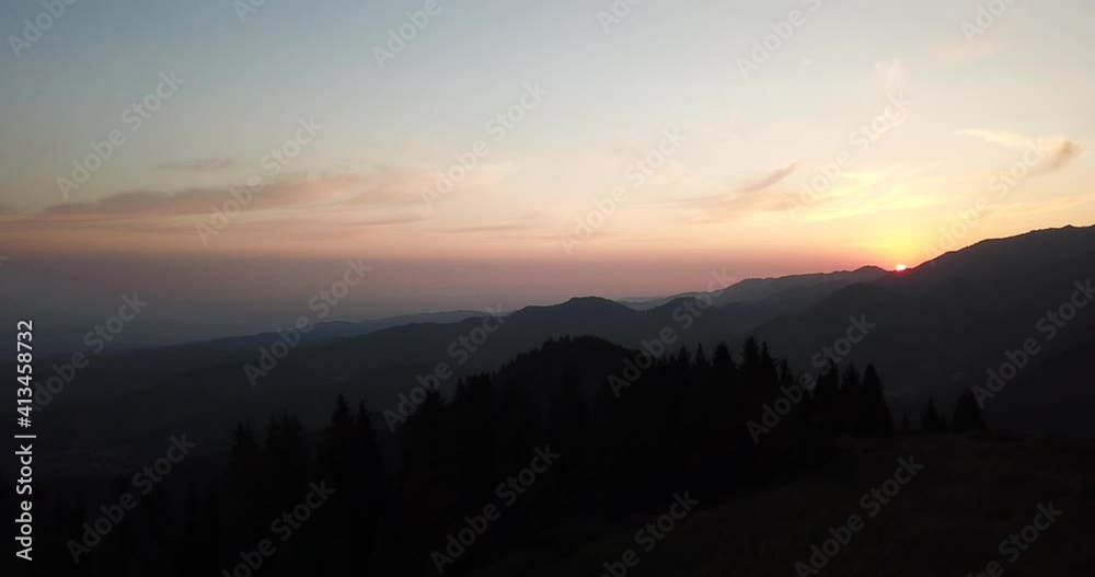 Dawn in the green mountains. High hills covered with grass and forest. Coniferous trees cast shadows from the sun. Trails and tents are visible. View from the drone from above. Kok Zhailau Mountains. Dawn in the green mountains. High hills covered with grass and forest. Coniferous trees cast shadows from the sun. Trails and tents are visible. View from the drone from above. Kok Zhailau Mountains.