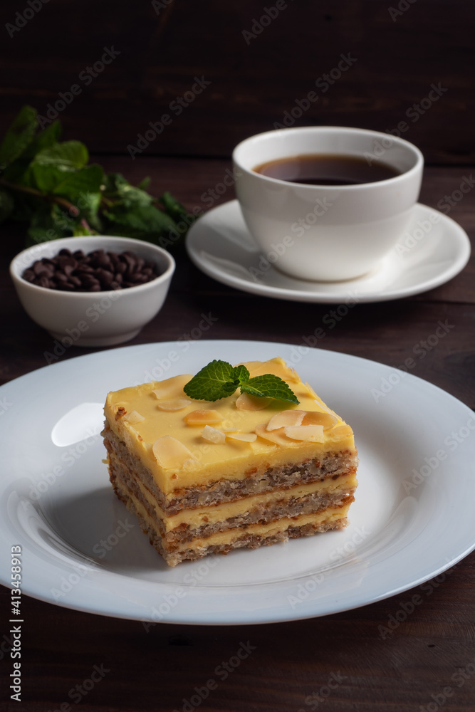 Banana sponge cake with nuts and mint. Delicious sweet dessert for tea, Dark wooden background.