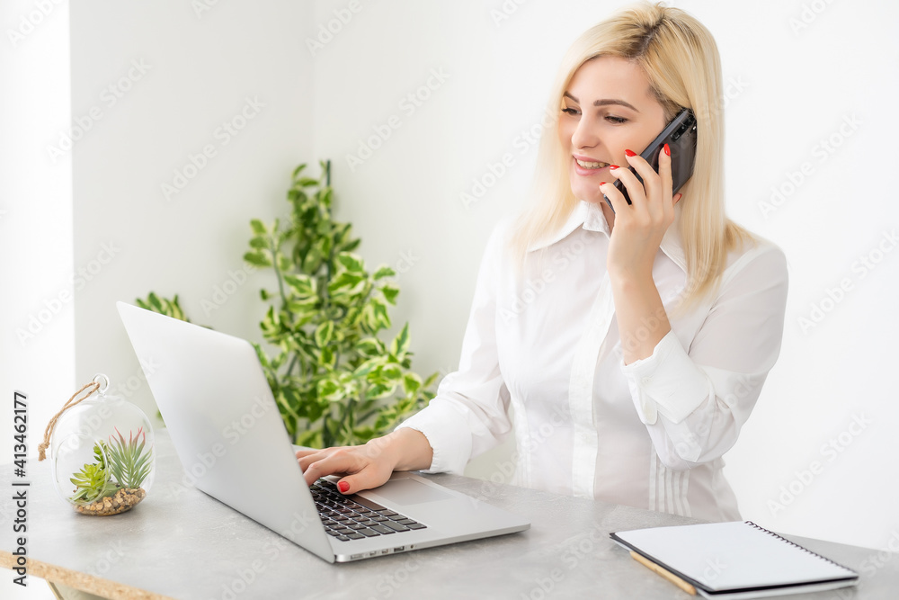 Portrait of a smiling young woman using laptop and smartphone Portrait of a smiling young woman using laptop and smartphone