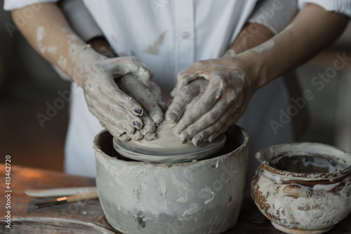 A loving couple in a pottery workshop. Romantic date. Hands in clay.