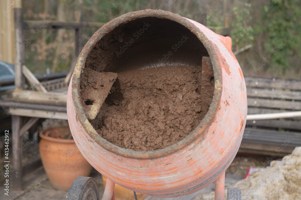 Mixing a Floor Screed in the Drum of a Rusty Old Cement Mixer on a Building Site in Rural Devon, England, UK Mixing a Floor Screed in the Drum of a Rusty Old Cement Mixer on a Building Site in Rural Devon, England, UK
