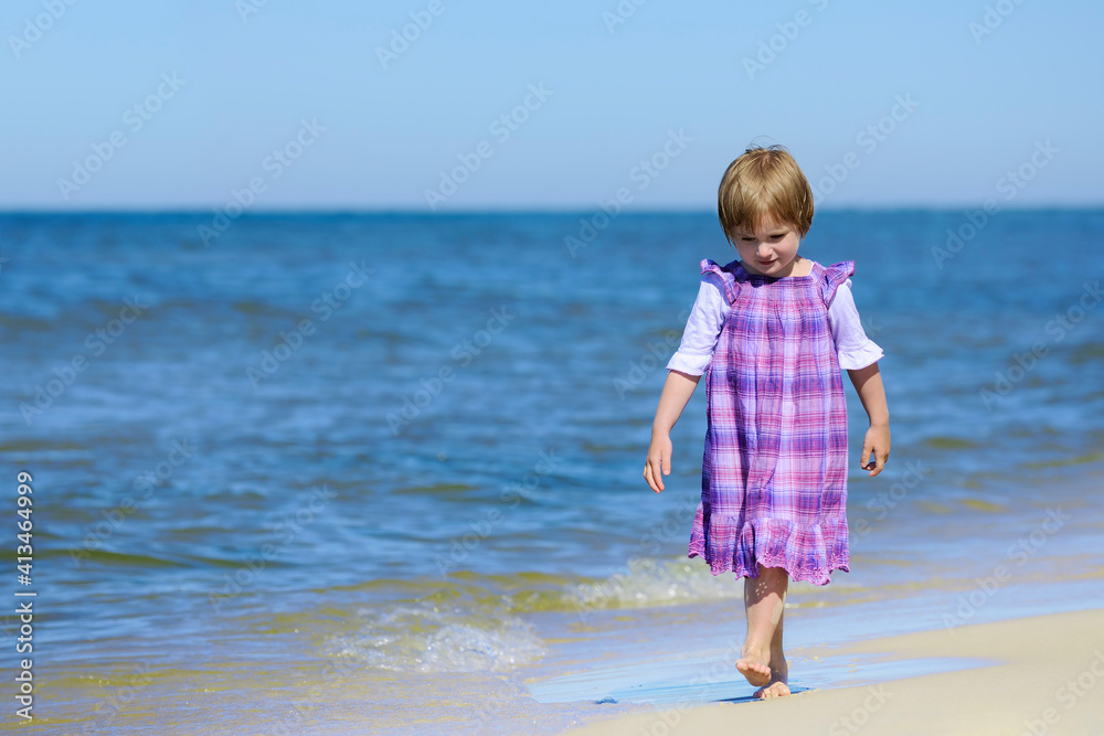 Beautiful girl in a dress walking on the beach Beautiful girl in a dress walking on the beach