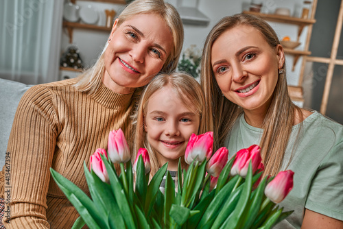 Grandmother, mother and daughter - family and generation. Family portrait with flowers. International Mother's Day, Women's Day and Spring Day.