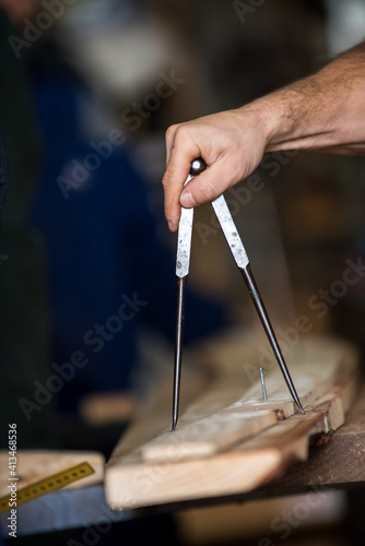 hands of a carpenter with compass