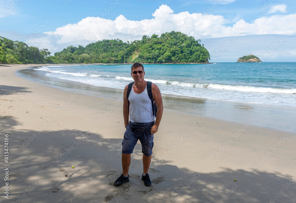 Man walk in Manuel Antonio beatiful tropical beach with white sand and blue ocean. Paradise. National Park in Costa Rica, Central America.. Man walk in Manuel Antonio beatiful tropical beach with white sand and blue ocean. Paradise. National Park in Costa Rica, Central America..