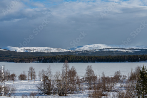 Lapland hills with boreal forest and frozen lake with snow during end of the winter