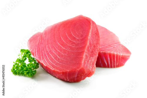 Fresh tuna fish fillet steaks garnished with parsley isolated on white background