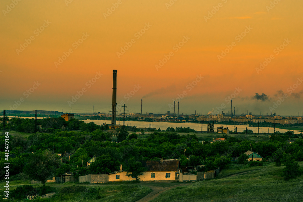 Golden sunset in a small town. Summer evening. Green hills, trees. Factory smog. In dali pond, Kazakhstan, the city of Temirtau. Stone quarry.