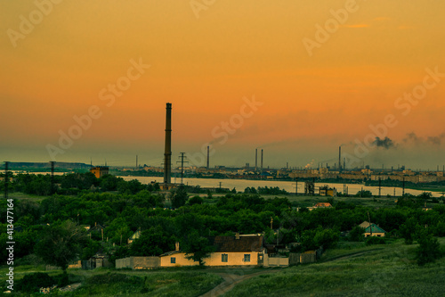 Golden sunset in a small town. Summer evening. Green hills, trees. Factory smog. In dali pond, Kazakhstan, the city of Temirtau. Stone quarry.