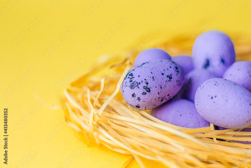 Purple Easter eggs lie in the nest on a yellow background close up. The concept of the holiday is Easter, Christ is resurrected. Banner. A place for text. Mock up. View from above. Selective focus