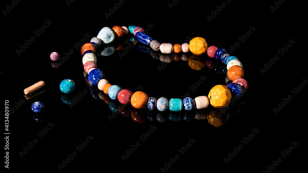Natural multi colored ceramic beads on a black background. Jewelry is made from clay. Ancient Slavic culture. Natural multi colored ceramic beads on a black background. Jewelry is made from clay. Ancient Slavic culture.
