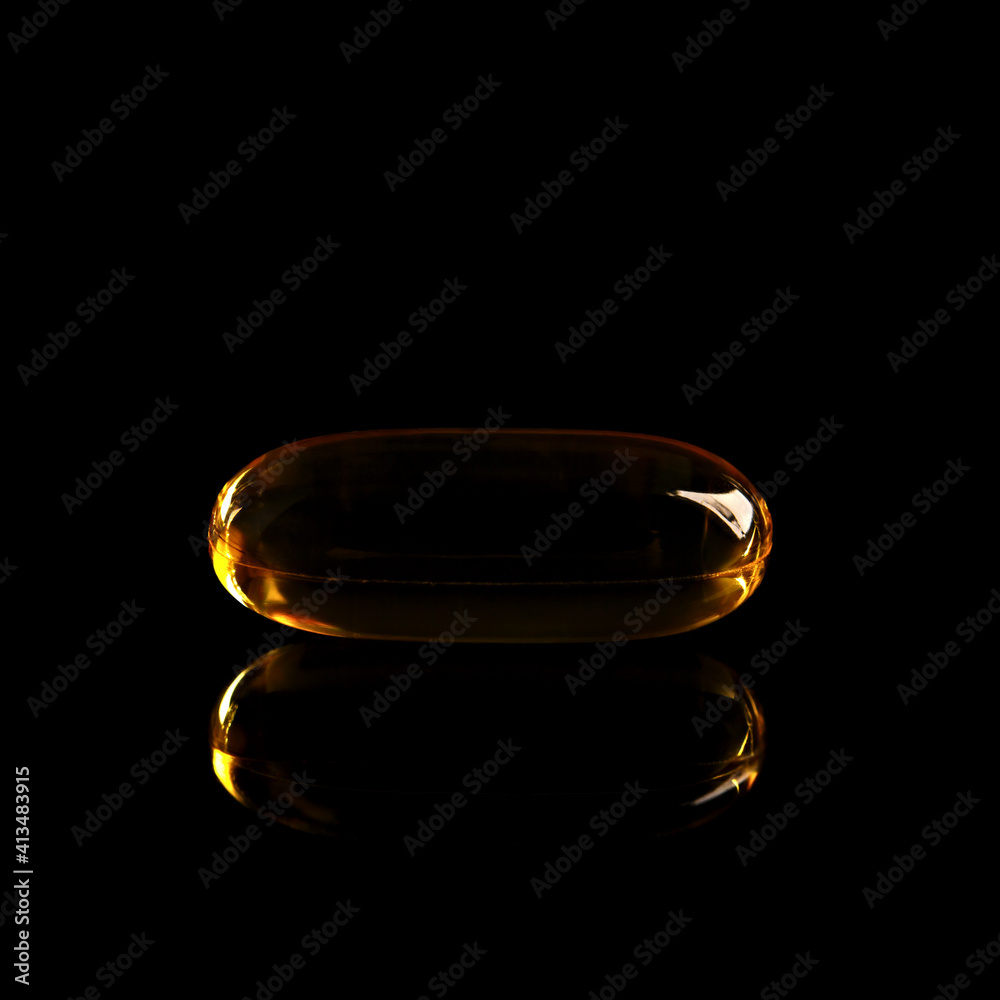 Fish oil concentrate in a soft gelatin capsule to support human health. Omega3 close-up on a black background. Fish oil concentrate in a soft gelatin capsule to support human health. Omega3 close-up on a black background.
