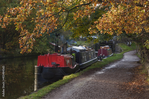 Boats moored up for the night alongside the towpath at the popular Hirst Lock on the Leeds and Liverpool Canal in West Yorkshire
