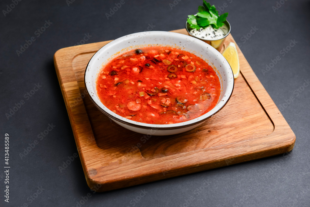 Solyanka rustic style over black background. Traditional Russian recipe, soup solyanka with different kinds of meat. Solyanka rustic style over black background. Traditional Russian recipe, soup solyanka with different kinds of meat.