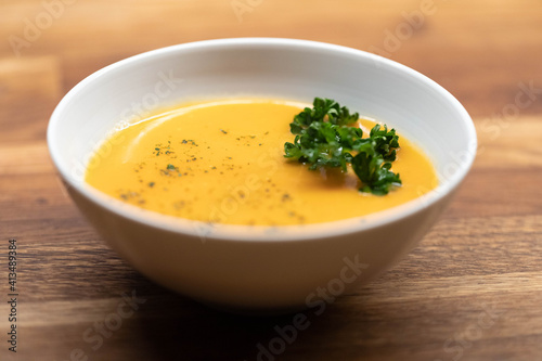 Gelbe Suppe mit Kräutern in Küche photo