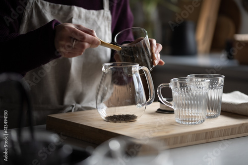 Woman is making hot tea in the kitchen.