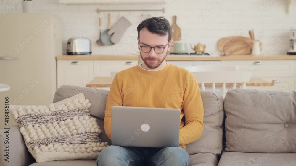 man sitting on sofa with laptop and working, concept of home office, remote work. man sitting on sofa with laptop and working, concept of home office, remote work.