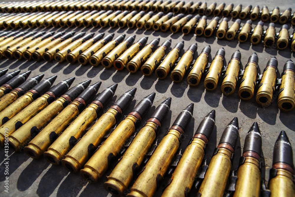 Large caliber shells. Many bullets for firearms lie on the asphalt. No people. Close-up Large caliber shells. Many bullets for firearms lie on the asphalt. No people. Close-up