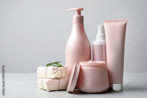 Set of hair care cosmetic products and soap bars on light grey marble table photo