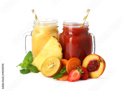 Mason jars of delicious juices and fresh ingredients on white background