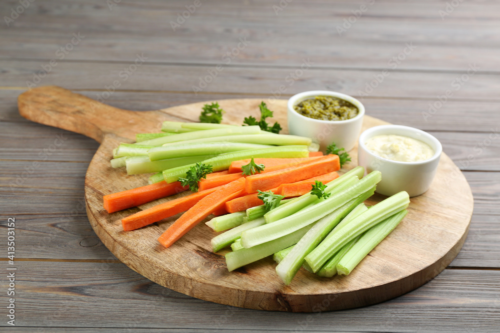 Celery and other vegetable sticks with different sauces on wooden table Celery and other vegetable sticks with different sauces on wooden table