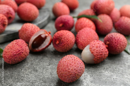 Fresh ripe lychee fruits on grey table, closeup