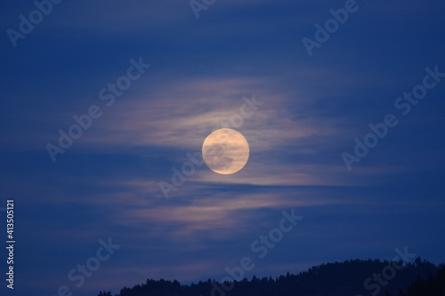 Full moon shinning through thin clouds